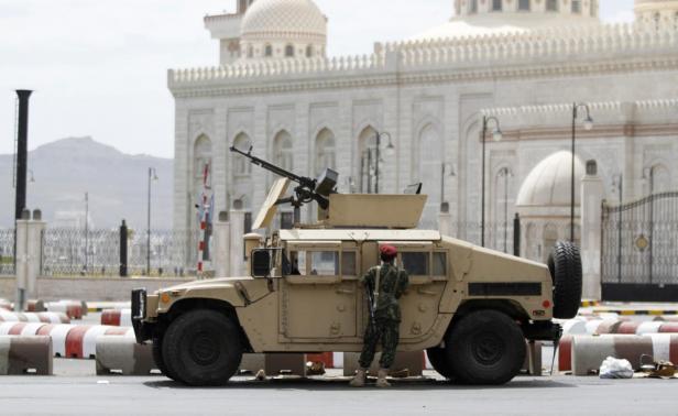 A soldier stands next to a military vehicle blocking Al-Sabeen street, which leads to the presidential palace in Sanaa